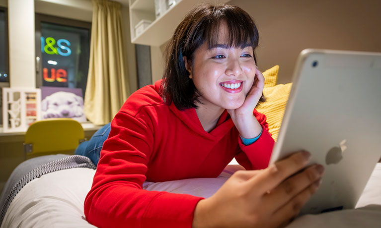 Female student smiling using her phone