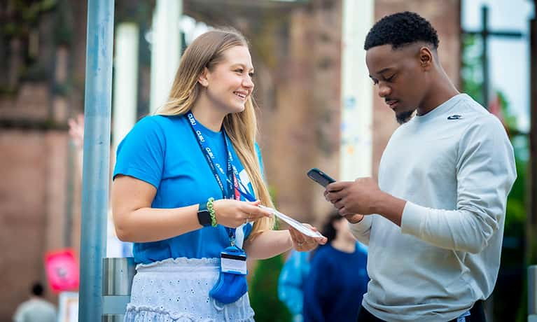 student support officer speaking to a student in Coventry Catheral ruins