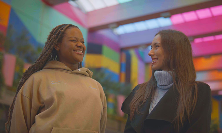 Two female students laughing together in Coventry