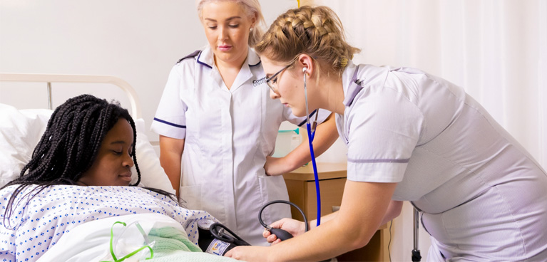 Nursing student taking an actor's blood pressure