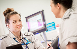 Nurse is seen smiling up at another healthcare worker who we can't see as they have their back to us