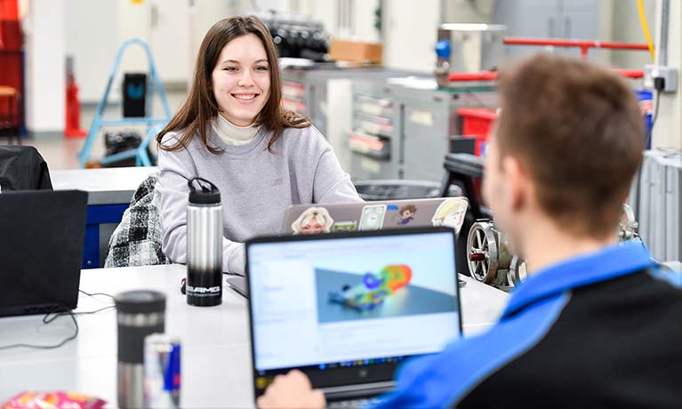 smiling female student working in a engineering laboratory