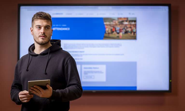 Student in front of a large wall-mounted screen