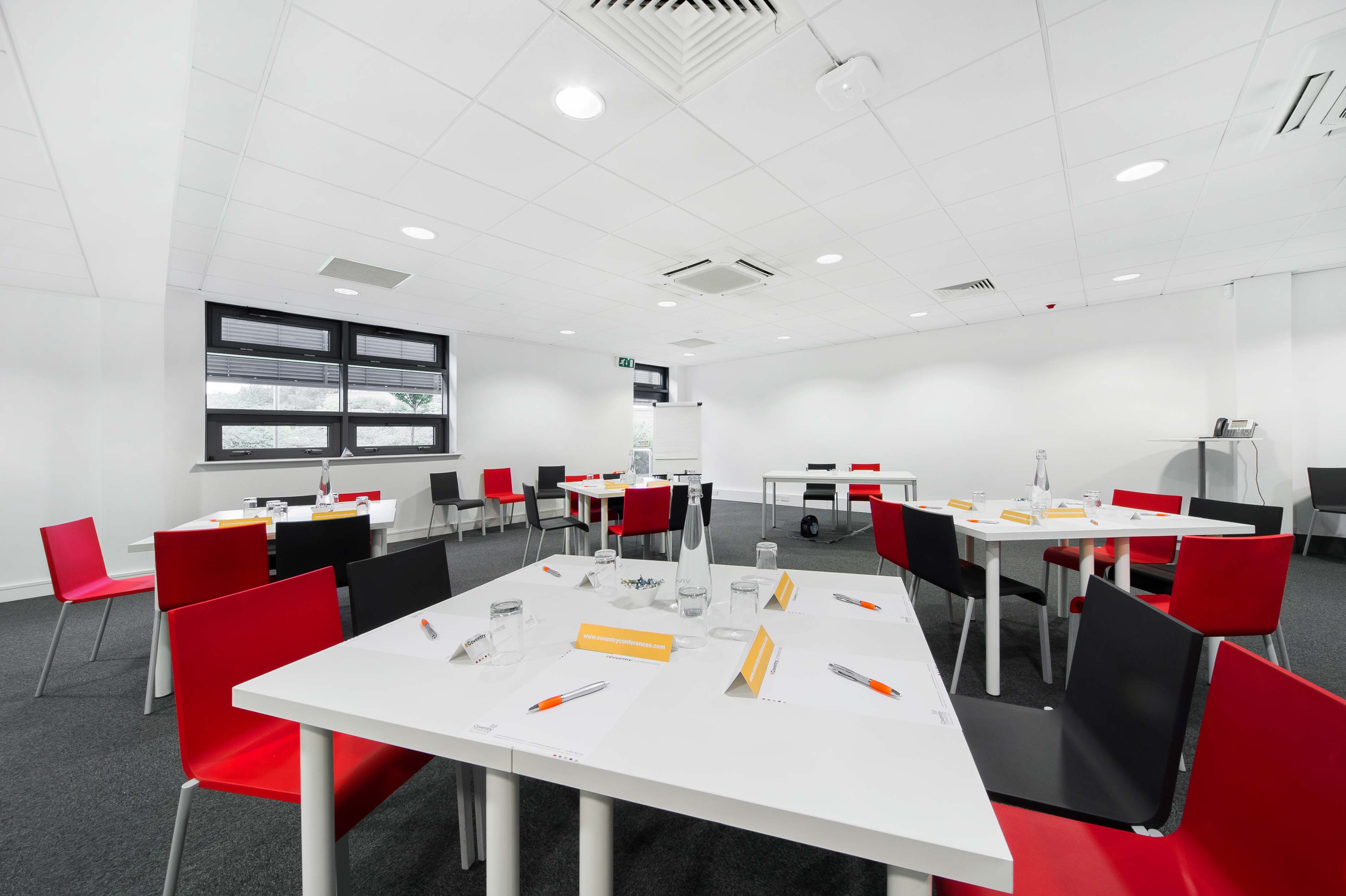 Simulation centre room with red and black chairs