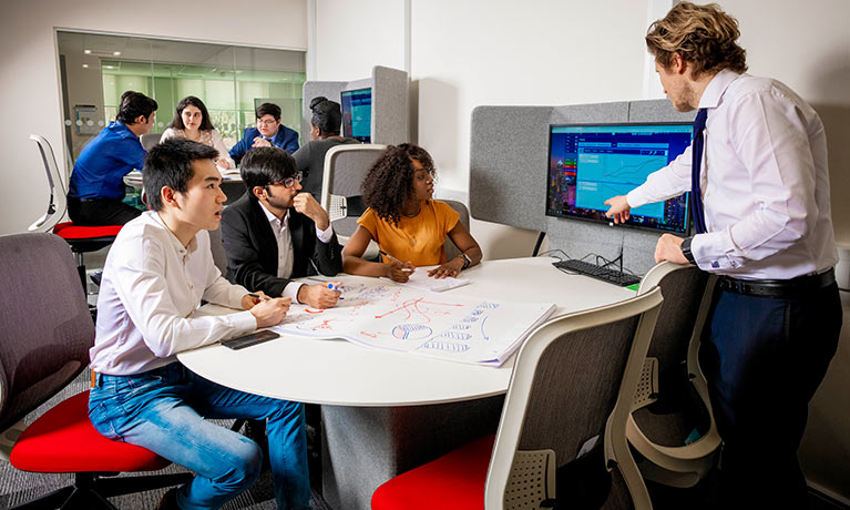 Students sat with a tutor in the Business Simulation Suite