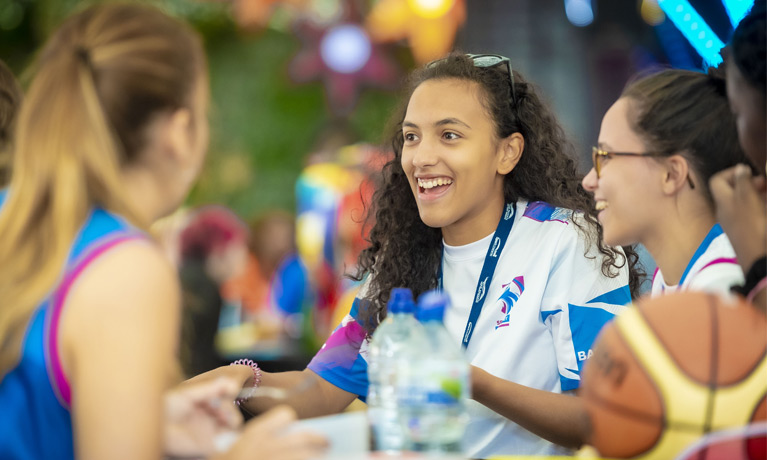 Students in a Students' Union society socialising and laughing around a table.