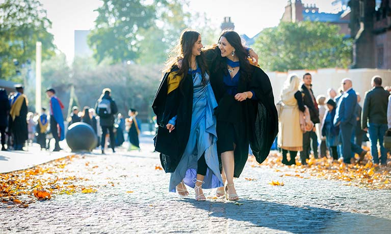 two girls with their arms around each other smiling and laughing 