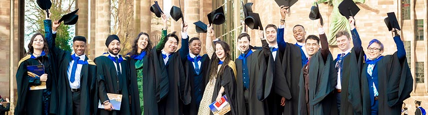 Group of graduating students throwing their mortarboard hats in the air