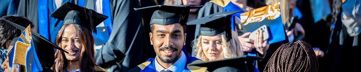 Group of graduates wearing hats and gowns after graduation