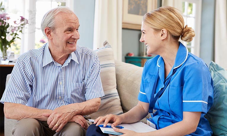 Nurse sitting with elderly man