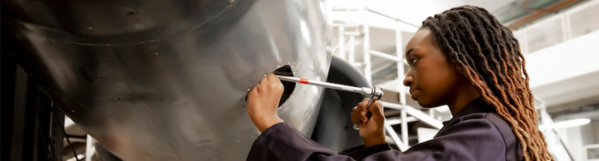 Female looking closely at a piece of equipment