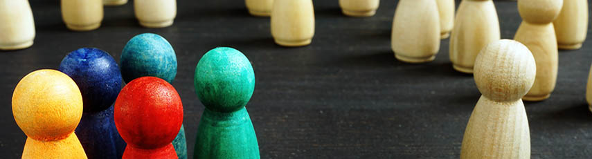 A space with lots of cream coloured wooden pins and then five coloured wooden pins all grouped together.