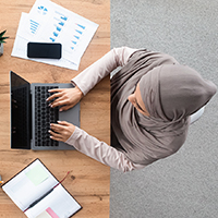 Aerial photo of an Islamic woman working at a laptop