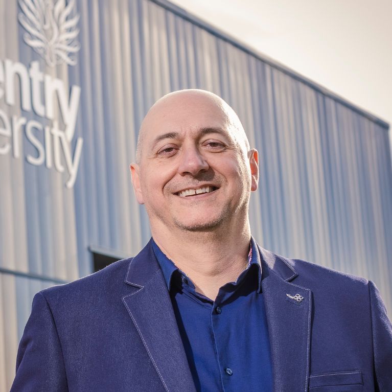 Petar Igic smiling in front of C-ALPS building