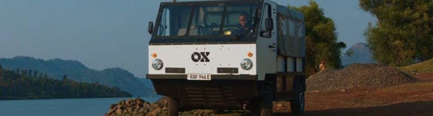 Truck driving on soil path next to a lake in Africa