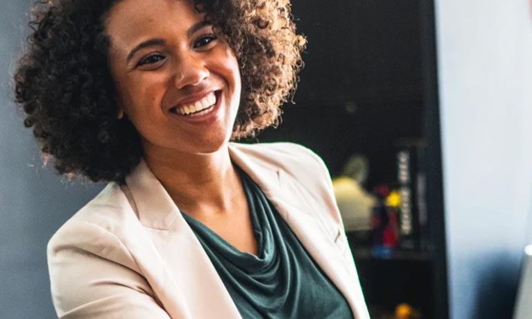 Female employee smiling and greeting someone off camera