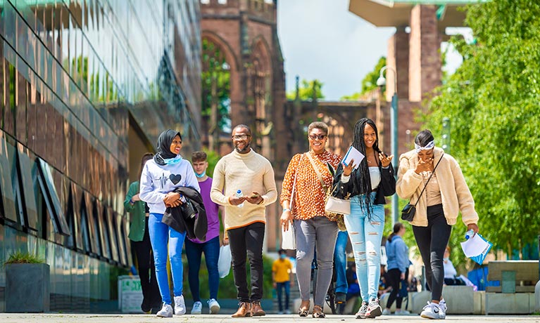 Group of smiling students walking on a sunny day