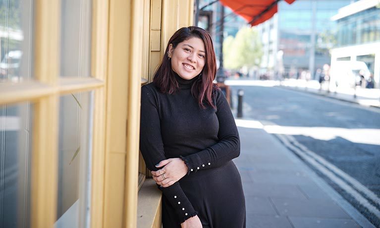 Smiling student leans against the window