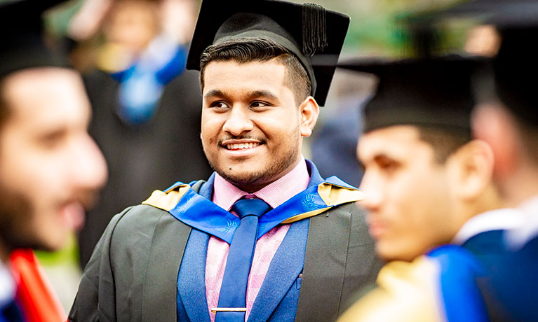 student smiling at their graduation cermony