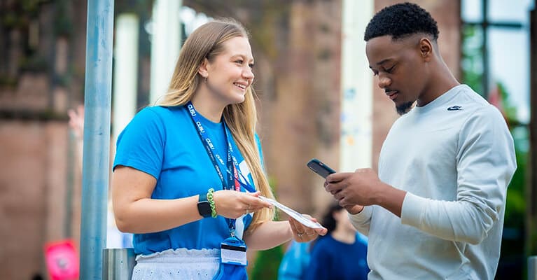 A student rep helping a student at an event.