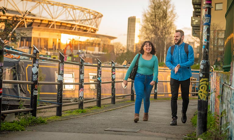 Two students walking along a canal