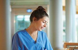 Young female nurse looking after her patients white wearing a light blue top