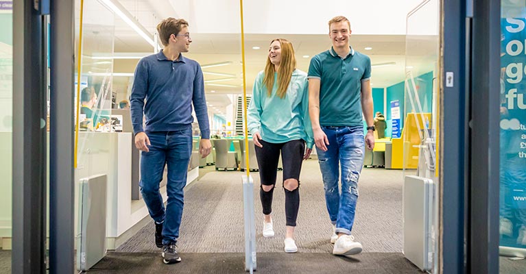 Three students walking towards the CU Scarborough doors