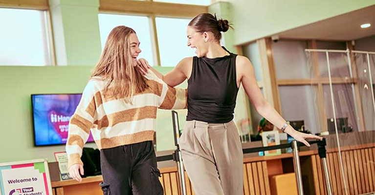 Students smiling together in a common room