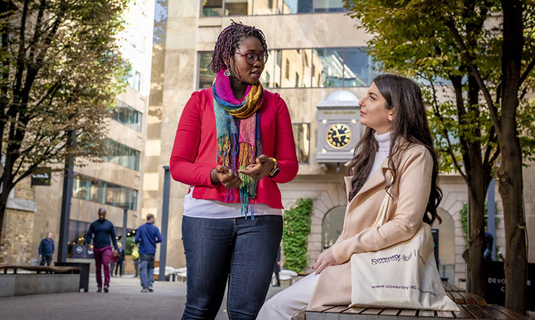 Students sat outside on the Coventry University London campus.