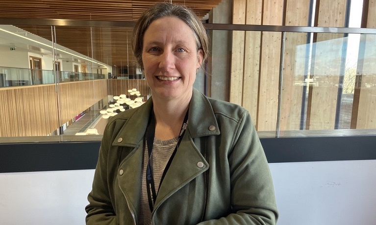 PhD student Mirabel Pelton sitting down at a table