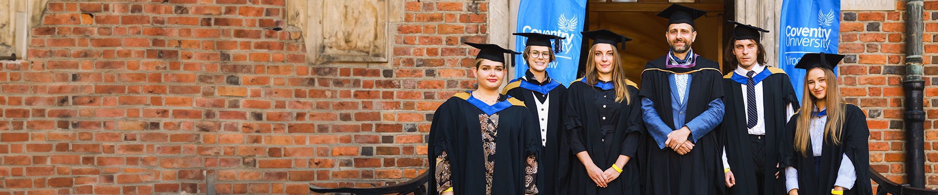 graduates standing out side of university building on a clear day